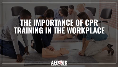 People in work environment doing CPR to a manikin in training.